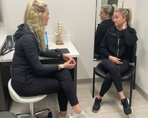 Two women talking during a consultation in a medical office.