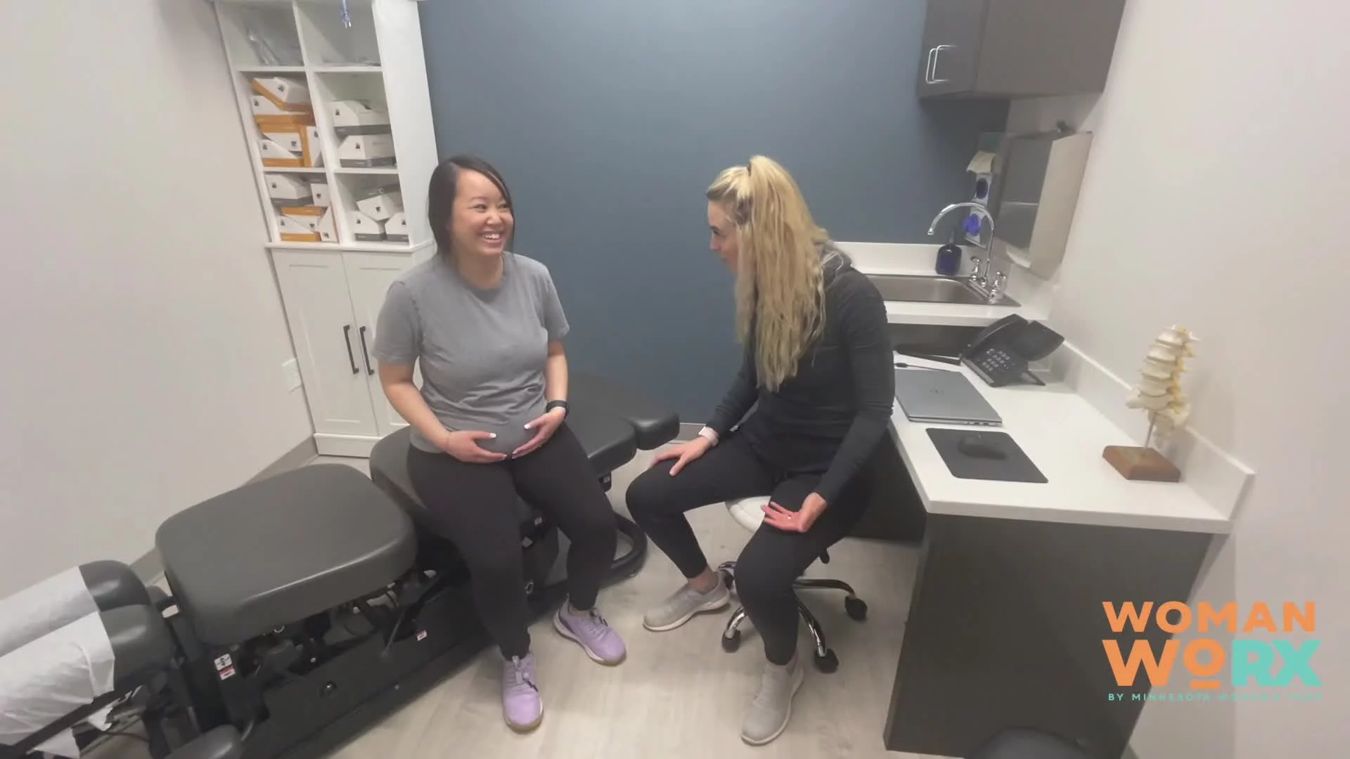 Pregnant woman and healthcare provider smiling during a consultation at Woman WoRX.